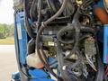 Close-up view of the engine compartment of a 2012 Genie Z 45/25 featuring numerous wires hoses and mechanical components