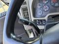 A close-up of the steering wheel of a 2008 International 7500 showing the gear shift lever and dashboard control panel with various gauges and indicators