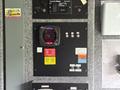 A control panel featuring various switches and gauges including a generator display with digital readout and warning labels