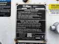 A metal instruction and warning label affixed to a machinery panel detailing operational guidelines and safety hazards related to the equipment