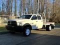 A 2014 RAM 5500 truck with a flatbed design painted in white with black accents and a spacious cab