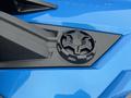 A close-up view of a blue 2020 Polaris SlingShot highlighting a textured black panel with a circular emblem featuring a star design in the center