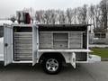 A 2019 Ford F-350 SD with an open service body revealing multiple tool drawers and compartments on the side