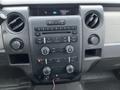 Interior dashboard of a 2010 Ford F-150 featuring control knobs buttons and a digital display