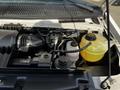 Engine compartment of a 2013 Ford Econoline showing the engine components including the air intake and coolant reservoir