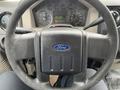 Steering wheel of a 2010 Ford F-250 SD with a Ford logo in the center and various gauges visible in the background