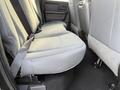 The rear seats of a 2015 RAM 1500 are grey fabric with adjustable seatbelts and a clean interior design