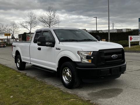 A white 2016 Ford F-150 pickup truck with a black front grille and silver wheels parked on a street