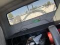 Interior of a 2007 International 7300 showing a flat shelf with storage underneath and a view of a cable reel through the rear window