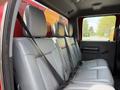 The rear seating area of a 2013 Ford F-550 featuring gray leather seats with seat belts attached and a spacious layout