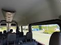 Interior view of a 2023 Mercedes-Benz Sprinter with multiple rows of black seats and overhead lighting visible