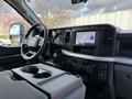 Interior view of a 2024 Ford F-550 featuring a steering wheel dashboard and touchscreen display with various controls and a center console