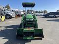 A green 2008 John Deere 3320 tractor with a front loader attachment and a covered cab facing forward