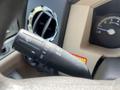 Close-up of the control stalk for windshield wipers and headlights in a 2014 Ford F-350 SD with a beige interior and dashboard elements visible