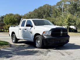 A white 2019 RAM 1500 Classic pickup truck is parked with a black grille and shiny silver wheels visible from the front angle