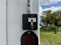 A black button panel with an upward and downward arrow indication mounted on a white surface