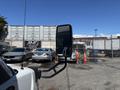 A 2020 Chevrolet Express van is parked with its side mirror prominently visible in the foreground