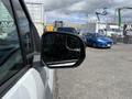 A side mirror of a 2021 Ford Transit Connect showing a reflection of other vehicles and raindrops on the mirror surface