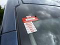 A 2017 Ford Transit 350 displaying a red certificate of approval sticker on its windshield with months listed from January to June