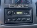 Dashboard control panel of a 2008 Ford E-350 featuring a radio display with buttons for volume tune and presets