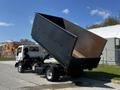 A 2009 Ford LCF 550 dump truck with its cargo bed raised, revealing the empty interior of the bed