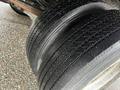 Close-up of three tires from a 2012 Mitsubishi Fuso FE showing tread patterns and slight water droplets on their surface