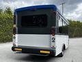A 2019 Chevrolet Express van with a blue top and black rear section featuring large windows and taillights