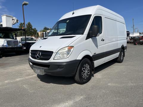 A white 2010 Mercedes-Benz Sprinter van with a high roof and black accents positioned at an angle with alloy wheels