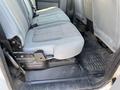 A gray interior of a 2015 Ford F-450 SD featuring a rear bench seat with textured fabric and a rubber floor mat