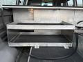 A metal storage box with two compartments inside the cargo area of a 2016 GMC Savana