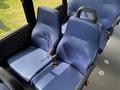 Two blue fabric-covered seats with seatbelts designed for a van or bus interior