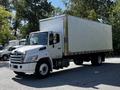 A 2021 Hino 338 truck with a spacious white cargo box and a front grille featuring prominent Hino branding