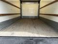 Interior view of an empty cargo area of a 2018 Hino 195 truck with wooden flooring and metal side panels