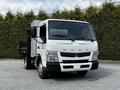 A 2015 Mitsubishi Fuso FE truck with a flatbed and cab in white color showcasing the front view