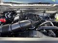 Engine compartment of a 2024 Ford F-550 showcasing the engine assembly with components like the air intake and various hoses and wiring