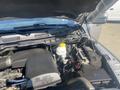 Close-up of the engine compartment of a 2021 RAM 1500 showcasing the 3.6L V6 engine with various components including a coolant reservoir and electrical parts