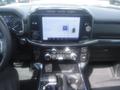 The interior dashboard of a 2022 Ford F-150 featuring a large touchscreen display with radio settings and climate controls