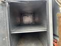 An empty compartment inside a black truck with two shelves visible