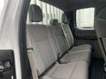 The interior of a 2017 Ford F-250 SD showing a gray upholstery back seat with headrests and seat belts