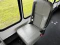 A single gray leather seat in a 2016 Ford Econoline with an adjustable seatbelt and a simple design