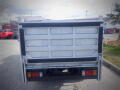 Rear view of a 2008 Isuzu Elf truck showcasing its closed cargo bed and tail lights