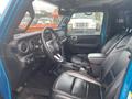 Interior view of a 2020 Jeep Wrangler showing black leather seats and a steering wheel with dashboard controls