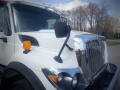 A 2016 International WorkStar 7500 truck with a shiny chrome grille an orange side light and a side mirror mounted on the driver's side