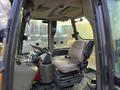 Interior view of a 2015 Case 590SN tractor showing the steering wheel control panel and beige operator seat