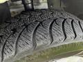 Close-up of a tire from a 2011 Dodge Grand Caravan showing a detailed tread pattern and slight moisture on the surface