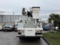 A 2007 International 4200 utility truck equipped with a white bucket lift and company branding on the bucket