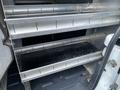 Interior shelving system of a 2013 Ford Transit Connect with three metal shelves including a black bottom shelf