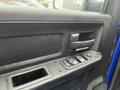 Interior door panel of a 2019 RAM 1500 Classic featuring a handle and controls for windows and locks with a textured surface and water droplets on it