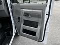 The image shows the driver's side door of a 2021 Ford E-450 with a gray panel featuring a handle and a speaker grille