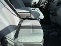 Interior of a 2015 Ford F-550 showing two front seats with seat belts and a console between them